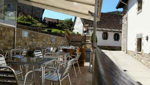 - une rangée de tables et de chaises sur la terrasse dans l'établissement Hostal Otsoa, à Ezcároz