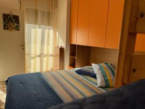 a bedroom with a bed with a blue blanket and a window at OltreMare - San Salvo Marina in Marina di Montenero