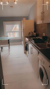 a kitchen with a refrigerator and a stove top oven at Contemporary 2nd floor shared flat near Bedford train station in Bedford