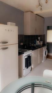 a kitchen with white appliances and a white refrigerator at 2nd floor shared flat near Bedford train station in Bedford