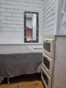 a mirror sitting next to a bed in a room at Hostel Feel Home in Blumenau