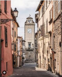 un callejón con una torre de reloj en la distancia en Nel Cuore del Borgo en Vitorchiano