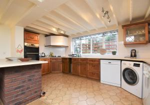 a kitchen with a washer and dryer in it at Sagewood Cottage in Seaton