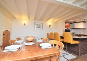 a dining room with a wooden table and yellow chairs at Sagewood Cottage in Seaton