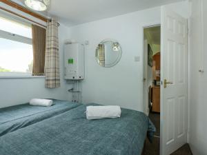 BeltonにあるWaveney Viewのベッドルーム1室(ベッド2台、窓、鏡付)