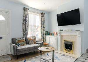 a living room with a couch and a fireplace at Beecroft Cottage in Cromer