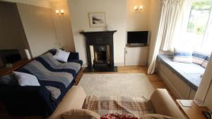 - un salon avec un canapé et une cheminée dans l'établissement Cockleshell Cottage, à Mumbles