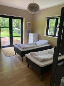 two beds in a room with two windows at Lake House Central Lyngby in Kongens Lyngby