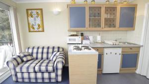 eine Küche mit einem Sofa, einem Stuhl und einer Theke in der Unterkunft Redcliffe Apartments G in Bishopston