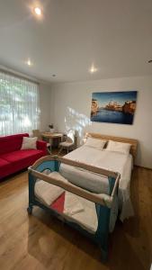 a bedroom with a bed and a red couch at Apartment Danes 35 in Klaipėda