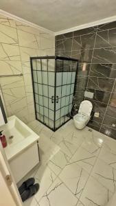 a bathroom with a white toilet and a sink at Sağlam PANSİYON in Uzungöl
