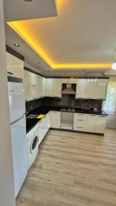 a kitchen with a white refrigerator and a dishwasher at Sağlam Apart Otel in Uzungol