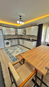 cocina con mesa de madera y lavadero en Sağlam Apart Otel, en Uzungöl