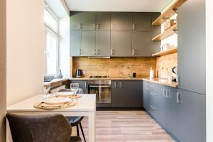 a kitchen with blue cabinets and a table with chairs at Karaliaus apartment in Kaunas