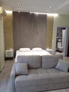 - un salon avec un lit et un canapé dans l'établissement Nefertiti, à Durrës