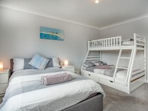two beds in a room with two bunk beds at First Floor Apartment - Uk44652 in Paignton
