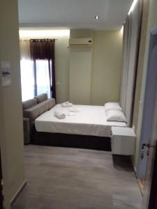 - une petite chambre avec un lit et un canapé dans l'établissement Nefertiti, à Durrës