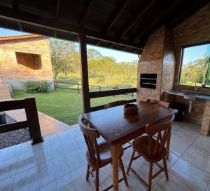 a dining room with a table and a fireplace at Costa Montana in Louro Müller