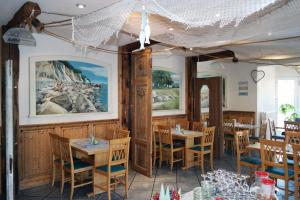 a restaurant with wooden walls and tables and chairs at Hotel und Restaurant Windland in Breege