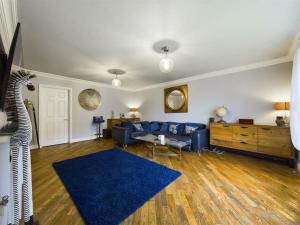 a living room with a blue couch and a blue rug at -- Huge -- 5-bedroom home & Private Gym by Tailored Accommodation in Swansea