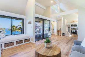 a living room with a table and a large window at Sealodge J8 in Princeville