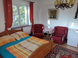 a bedroom with a bed and two chairs at Pokoje Olech in Wrzosowo