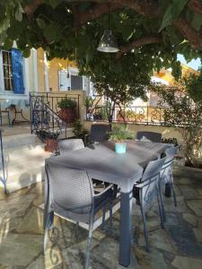 une table et des chaises assises sous un parasol dans l'établissement Kali’s comfort, à Karavomylos