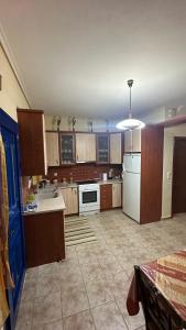 a large kitchen with wooden cabinets and white appliances at Kali’s comfort in Karavomylos