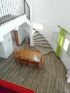 une salle à manger avec une table en bois et un escalier dans l'établissement La case ronde avec Piscine -Ndayane, à Ndéyane