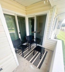 a porch with chairs and tables on a house at Modern Rocket City Condo -- 3 min to Mid-City in Huntsville