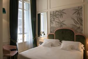 a bedroom with a white bed with a large window at Hotel La Gemma in Florence