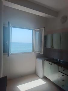 cocina con ventana grande con vistas al océano en Appartamenti La Spiaggia en Gallipoli