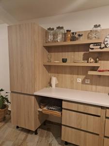 uma cozinha com armários de madeira e um balcão branco em Bekeke em Capesterre
