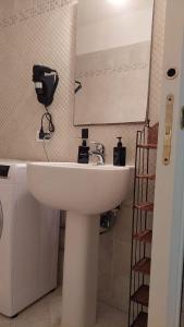 y baño con lavabo blanco y espejo. en Casa Vacanze I Leoni Empoli, en Empoli