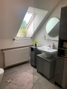 ein Bad mit einem Waschbecken und einem Spiegel in der Unterkunft IQBAL-Hütte (die Moorperle) in Beverstedt