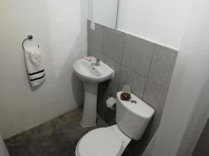 a white bathroom with a toilet and a sink at Pacific Spot San Miguel in Lima +8 photos