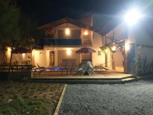 una casa con un patio de juegos delante de ella por la noche en Flat Villagio Coqueiro en Luis Correia
