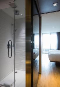 a bathroom with a shower and a bed in a room at AC Hotel Cincinnati at Liberty Center in West Chester