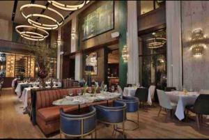 a dining room with tables and chairs in a restaurant at Luxury 1 BDR , Rooftop POOL, Gym, in Downtown D2 in Santo Domingo