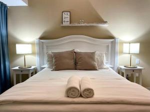 a bedroom with a large white bed with two lamps at Luxury 1 BDR , Rooftop POOL, Gym, in Downtown D2 in Santo Domingo +44 photos