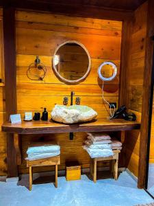 a bathroom with a mirror and a wooden wall at Confraria Colonial Hotel Boutique in Mairinque