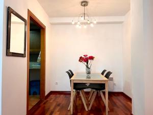 a dining room table with a vase of flowers on it at Apartament Els Raiers in Rialp