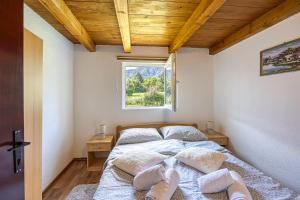 a bedroom with a bed with pillows and a window at Holiday home Veki*** in Korenica