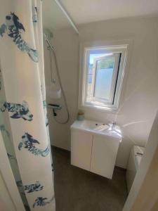 a small bathroom with a sink and a window at Moderne minihus ved havet in Sørvågen