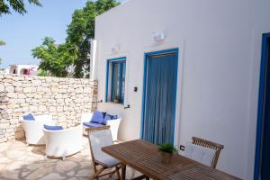 a patio with a table and chairs and a wall at Villa Azzurra a pochi passi dal mare in San Vito lo Capo