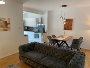 a living room with a couch and a table with chairs at Luxuswohnung Nähe Köln Bonn in Troisdorf