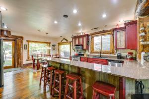 a large kitchen with red cabinets and bar stools at Weber River Cabin in Oakley with Private Hot Tub! in Oakley