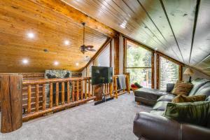 a living room with a couch and a tv in a cabin at Weber River Cabin in Oakley with Private Hot Tub! in Oakley