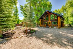 a log cabin in the woods with a tree at Weber River Cabin in Oakley with Private Hot Tub! in Oakley