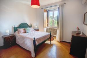 um quarto com uma cama e uma janela em Quinta das Oliveiras em Arcos de Valdevez